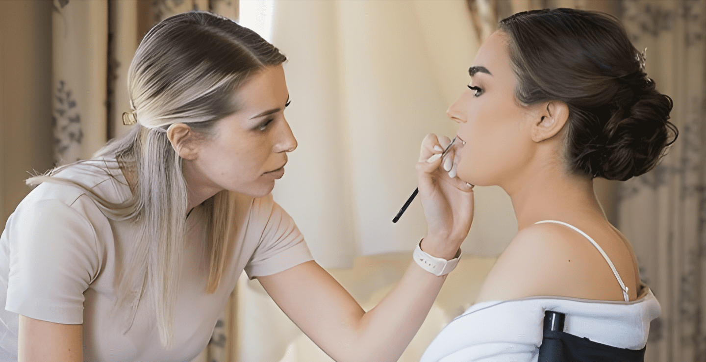 Makeup artist applies lipstick on a bride